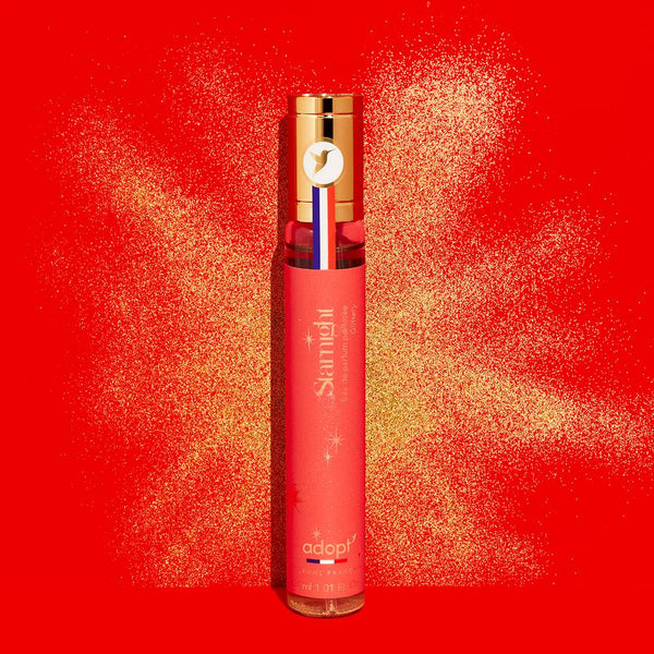 Adopt Starnight Eau de Parfum Pailletee Glittery, a shimmering fragrance in a red bottle with a gold cap,