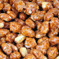 Adopt Absolument Rose product with a close-up texture of candied peanuts, showcasing their glossy, sweet coating