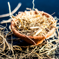 Adopt Blue Suit product image showing a close-up detail of dried vetiver roots and grass in a small terracotta bowl