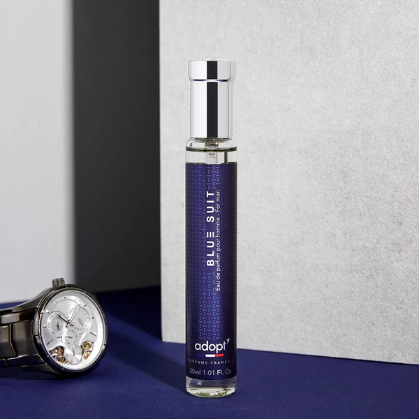 Adopt Blue Suit eau de parfum for men, 30ml, in a clear bottle with a blue label, next to a watch