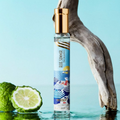 Adopt Blue Summer eau de parfum with a gold cap and a beach-themed label, standing in water with a sliced lime and driftwood