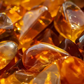 Adopt Fleur D'oranger Ensoleillee fragrance with a close-up of amber-colored resin pieces, showcasing their warm,