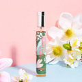 Adopt Fleurs De Mon Jardin perfume bottle with a floral design, standing upright amidst white flowers and a pink and blue