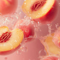 Adopt Peachy Beachy Body & Hair Mist with fresh peach halves and water splashes, creating a vibrant and refreshing scene