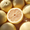 Adopt Pomelo Fantastique with a close-up top view of a halved pomelo showing its pinkish flesh surrounded by whole fruits