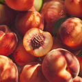 Adopt Quelques Mots D'Amour with a close-up of fresh peaches, one cut open to reveal the pit and juicy flesh