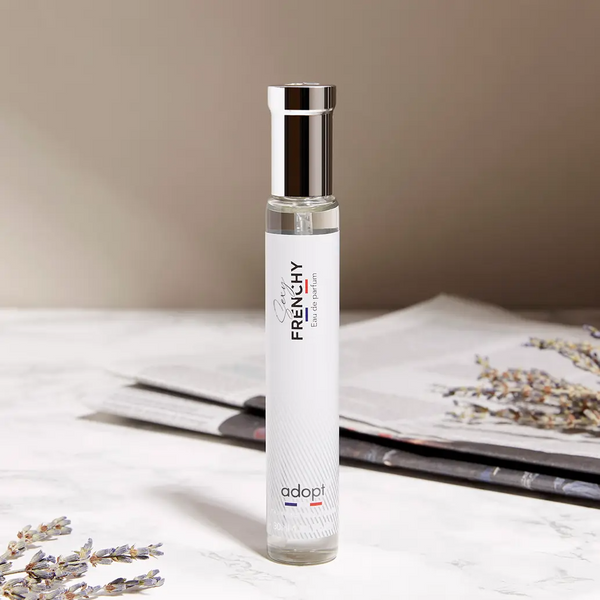 Adopt Sexy Frenchy Eau de Parfum bottle with a silver cap on a marble surface with lavender sprigs