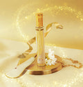 Adopt Sublimissime glittery eau de parfum with a golden ribbon, white flowers, and a pear slice on a gold tray