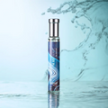 Adopt Surf The Wave Eau de Parfum in a sleek bottle with a blue and white wave design, standing on a reflective water surface