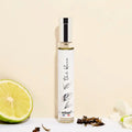 Adopt The Blanc (White Tea) perfume bottle with a silver cap and white label, next to a lime and dried tea leaves