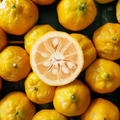 Adopt Yuzu Vivifiant with a top-down view of several whole yuzus and one cut in half, revealing its texture