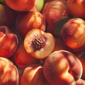 GD11 Repair Ampoule Program close-up of fresh peaches, one cut open to show the pit and juicy texture