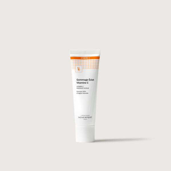 Novexpert Vitamin C Radiance Scrub in a white tube with an orange top, front view on a white background